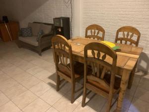 Hostal Blanquita في سان سلفادور: طاولة طعام خشبية مع أربعة كراسي وأريكة