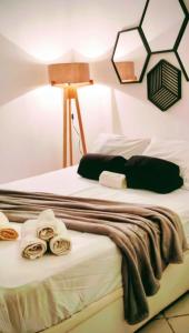 two beds with towels and a lamp on them at Apto Térreo Recreio Praia 9 min a pé com Ar Cond in Rio de Janeiro