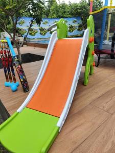 un toboggan vert et orange sur une aire de jeux dans l'établissement Sivarama gaeden resort 5 star stay & swimming pool room no 5 bheemunipatbam beach road to dorathota road, à Bhīmunipatnam 187 autres photos