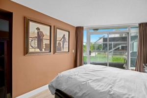 a bedroom with two pictures on the wall and a bed at Luxury 2BR Designer Apartment - Prime Downtown Location! in Vancouver +14 photos