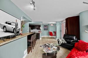 a living room with a red couch and a kitchen at Luxury 2BR Designer Apartment - Prime Downtown Location! in Vancouver