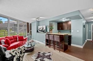 a living room with a red couch and a kitchen at Luxury 2BR Designer Apartment - Prime Downtown Location! in Vancouver