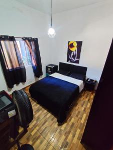 a bedroom with a bed with a blue bedspread at Casa no lago de Javary in Miguel Pereira