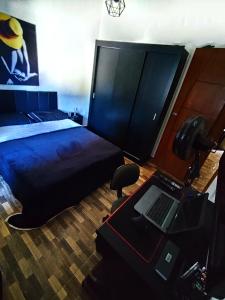 a bedroom with a bed and a desk with a laptop at Casa no lago de Javary in Miguel Pereira