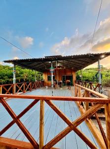 a wooden house with a roof over a body of water at Recanto Paraiso Tropical- Praia Ajuruteua in Bragança