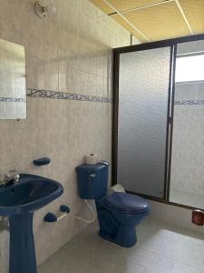 a bathroom with a blue toilet and a sink at Cabañas Gachalá - Centro vacacional El jazmín in Gachalá +22 photos