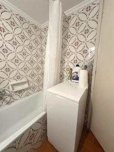 a small bathroom with a white refrigerator and a bath tub at Dreams in Kavala
