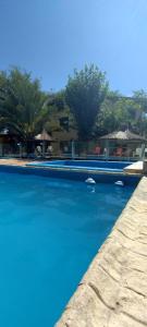 a swimming pool with blue water in a resort at Santa Rosa Cabañas in Santa Rosa de Calamuchita