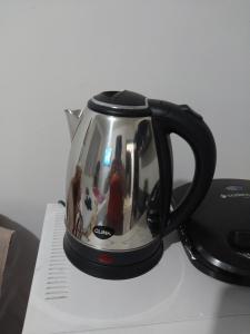 a tea pot with a picture of people on it at Quarto com banheiro casa da Mari in Maringá