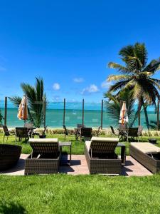 a group of chairs and umbrellas on the beach at Brisas Tropical Flat in Conde