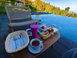 a tray of food on a table with a cup of coffee at Munduk Pondok Canopee in Ambengan