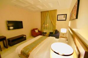 a hotel room with a bed and a tv at شقق درة المندق للشقق المخدومة - اقتصادي in Az Zarqāʼ