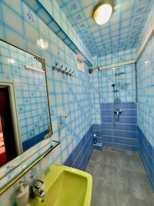 Un baño con paredes de azulejos azules y blancos y un lavabo amarillo. en Serene Central Home Near Beach - High Speed WiFi, Free Parking, en Agadir