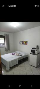 a bedroom with a bed and a stove at Quarto com banheiro casa da Mari in Maringá