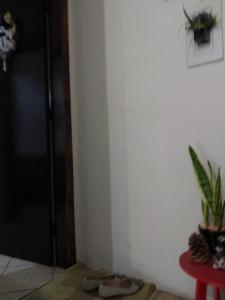 a corner of a room with a door and a table at Quarto com banheiro casa da Mari in Maringá +4 photos