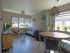a living room with a table and a couch at Modern 4-person bungalow near beach in Petten