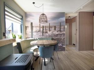 a living room with a table and a laptop at Modern 4-person bungalow near beach in Petten +9 photos