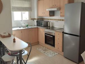 a kitchen with a stainless steel refrigerator and a table at Inviting holiday home with pool in Palomares