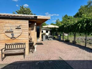 a wooden building with a bench on a brick patio at Holiday home in Elim for family in Elim
