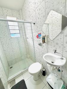 a white bathroom with a toilet and a sink at Hostel Estação Maracanã in Rio de Janeiro
