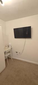 a flat screen tv on a wall in a room at Cosy Rooms in London
