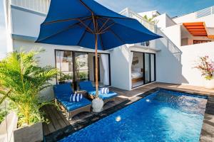 a villa with a swimming pool and a blue umbrella at Villa Three & Three in Nusa Dua