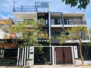 an apartment building with balconies and trees in front of it at Pupon Villa in Quảng Ngãi