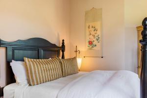 Un dormitorio con una cama con cabecero de madera. en Bozeman Farmstead - Country Side Stay & Mtn Views, en Bozeman