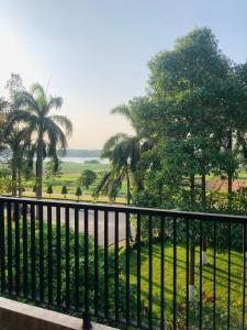 a balcony with a view of a park with palm trees at Pupon Villa in Quảng Ngãi