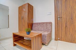 a living room with a chair and a table at FabHotel Adiyogi Aura in Indore