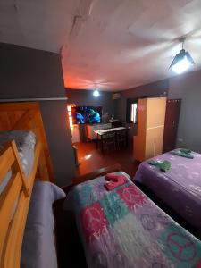 a room with two beds and a dining room at Hospedaje Tidae in Tinogasta