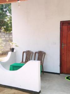 two chairs and a table in a room at Fr Resort in Arugam Bay +1 photo