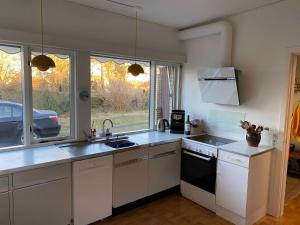 a kitchen with a sink and a stove at Cottage With 400 M To The Water And The Marina in Østerby Havn +29 photos
