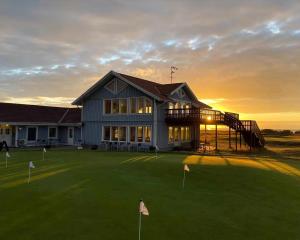 a building with a golf course with a clubhouse at Cottage With 400 M To The Water And The Marina in Østerby Havn