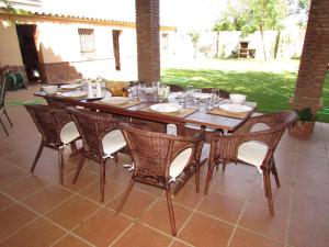 una mesa de madera y sillas en un patio en Casa Rural Orégano en Carmona