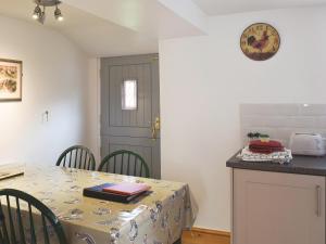 a kitchen with a table with a table cloth on it at Gable Cottage in Keswick