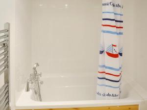 een bad met een douchegordijn in de badkamer bij Driftwood in St Ives