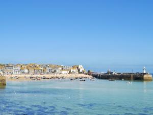 een strand met een groep boten in het water bij Driftwood in St Ives