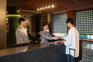 a group of people standing at a counter at Suzhou Shantang Street Night Mooring Hotel in Suzhou