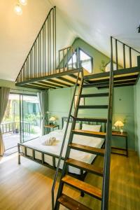 a bedroom with a bunk bed and a spiral staircase at Green Garden House กรีนการ์เด้นเฮ้าส์ นครพนม in Nakhon Phanom