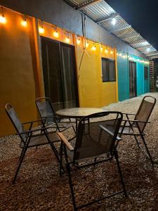 two chairs and a table in front of a building at Villas Maricela in Chorro