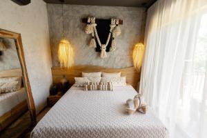 a bedroom with a large bed with white sheets at "Designer Cave Loft" in Tulum Hotel Zone - Beach Club included in Tulum +111 photos