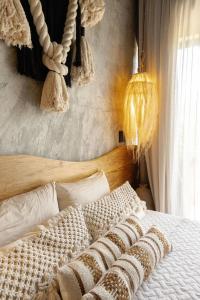 a bed with a wooden headboard and pillows on it at "Designer Cave Loft" in Tulum Hotel Zone - Beach Club included in Tulum