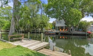 una casa con un molo e una casa sull'acqua di The White House at Weeki Wachee a Spring Hill