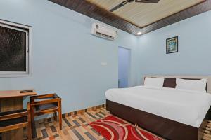 a bedroom with a bed and a desk and a bed at Super Hotel O Drip Inn in Bheta +18 photos