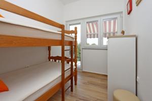 ein Zimmer mit zwei Etagenbetten und einem Fenster in der Unterkunft Holiday house with a parking space Jakov Polje, Novi Vinodolski - 24824 in Klenovica