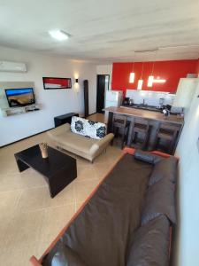 a living room with a couch and a kitchen at Arenas del Diablo in Punta Del Diablo