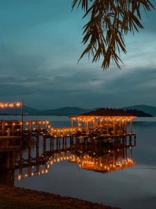 a dock with lights on the water at night at Hotel Boutique La Casa Del Lago in Tzintzuntzán