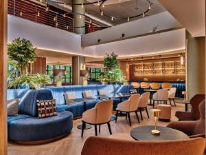 a lobby with blue couches and tables and chairs at Crowne Plaza Bratislava by IHG in Bratislava