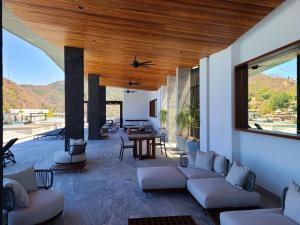 ein Wohnzimmer mit weißen Sofas und einer Holzdecke in der Unterkunft Madero 320 in Puerto Vallarta